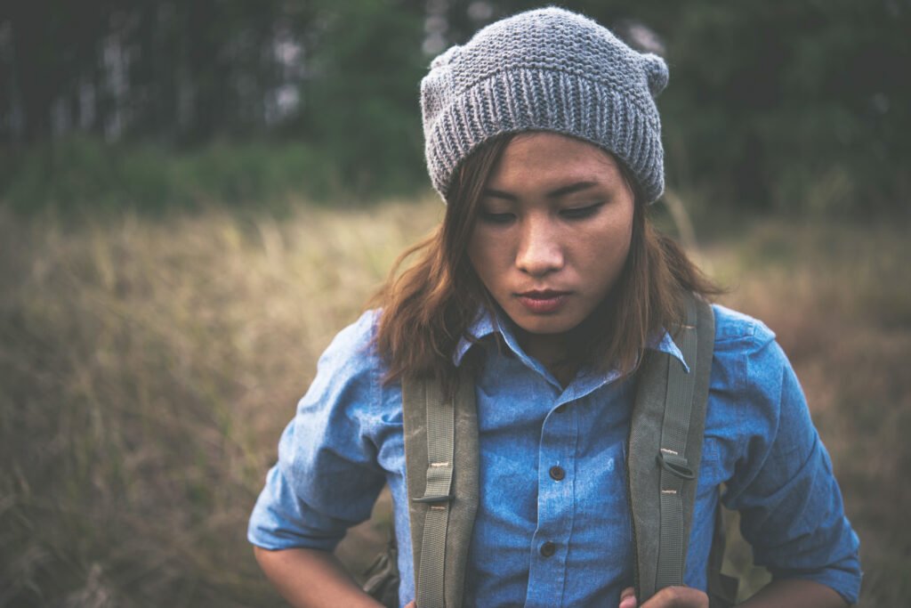 young-hipster-girl-with-backpack-walking-through-summer-field